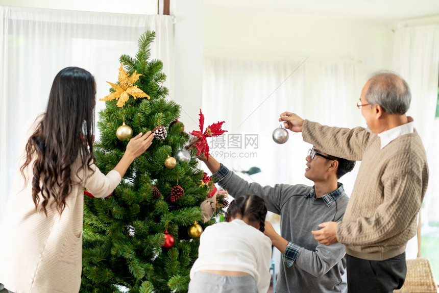 多代亚洲家庭装饰圣诞树爸妈女儿孩和祖父装饰圣诞树为快乐和节日的季问候做准备图片