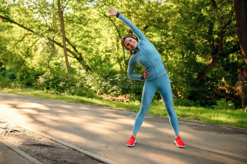 女跑者在阳光明媚的白天参加体育活动健康的生方式户外运动员公园健身培训妇女耳机图片