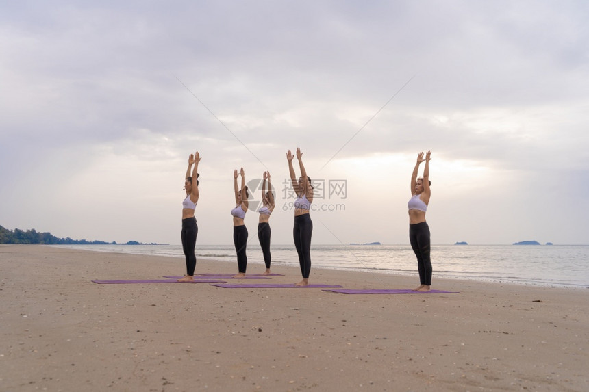 参加瑜伽班俱乐部的亚洲妇女群体在自然海滩和滨户外开展运动和瑜伽活学习体育和娱乐概念图片