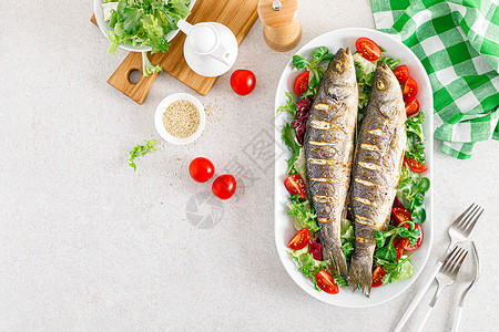 海巴斯或贝鱼烤和新鲜蔬菜沙拉番茄和生菜及健康午餐食品顶视图片