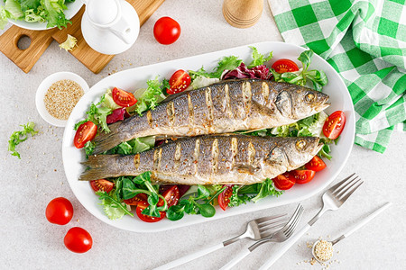 海巴斯或贝鱼烤和新鲜蔬菜沙拉番茄和生菜及健康午餐食品顶视图片