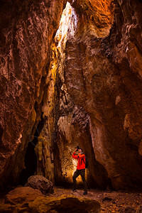 探险者摄影师探索洞穴中的光线图片