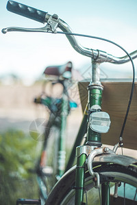 旧的式回转自行车头反射器和模糊背景的正面照片图片