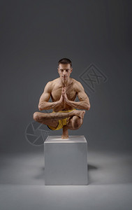 雄瑜伽让巴朗人手举着难摆的姿势在祭坛冥想姿势灰色背景上强壮的人在做瑜伽运动麻培训最高浓度健康的生活方式瑜伽让巴朗人举着难摆的姿势背景图片