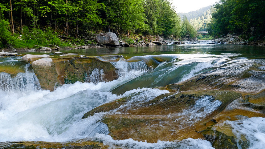 山上河流的岩石级联和瀑布的美丽景象图片
