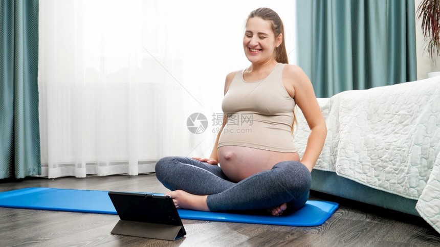 孕妇通过平板电脑与瑜伽老师交谈图片