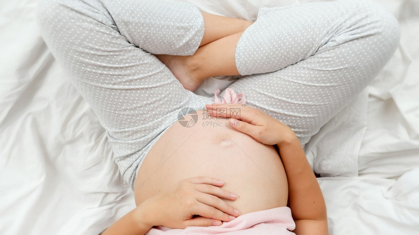 孕妇穿着睡衣抚摸肚子图片
