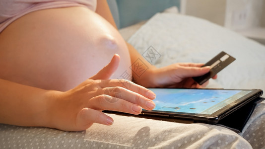 孕妇使用平板电脑在网上购物图片