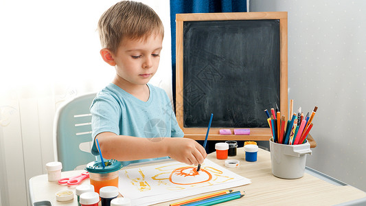 小男孩在学校课堂上画有创意的儿童画在家接受禁闭期间的教育家被禁闭期间的育背景图片