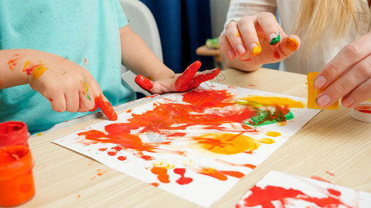 利用白纸上彩色涂料用手和指亲缝合成人和儿童画创造教育和艺术技能发展概念利用白纸上彩色涂画用手和指缝合成人儿童画创造教育和艺术技能背景