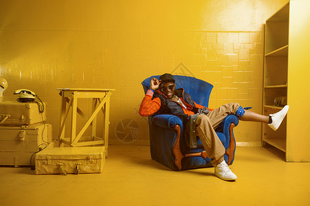 rapper歌舞手唱脱舞表演Rapper与黄色音调一起坐在演播室的椅子上背景