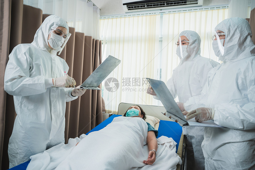 全套防护服和外科口罩的专业医生正在检查院控制区的感染病人图片