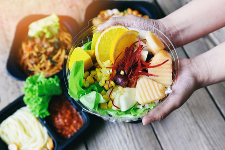 将家里桌上的盒式食品包装带走的塑料食品交付健康盒与水果生菜蔬沙拉酱服务食品订单在线交付背景图片