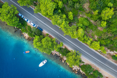 在美丽的绿林和春季日落时的海岸美丽绿林和海岸空中道路景色公船只蓝水夏季树木上有汽车的多彩景观克罗地亚高速公路的顶端景色背景图片