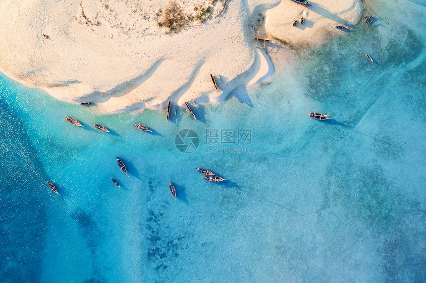 热带海岸的渔船空中观察日落时有白沙滩夏季在非洲桑给巴尔旅游有船艇绿棕榈树清蓝水的风景图片