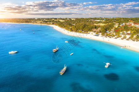 热带海岸的游艇和船只空中景象日落时沙滩非洲桑给巴尔暑假有船游艇清蓝水绿棕榈树天空的风景背景图片