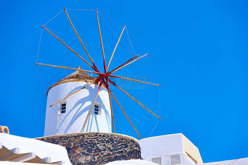 希腊桑托里尼岛风车对抗蓝色天空图片