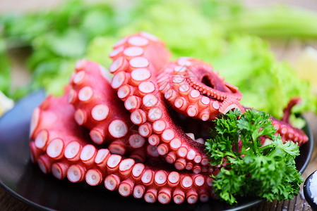 海鲜蔬菜沙拉黑盘上新鲜的章鱼食品煮熟的鱿鱼沙拉菜类海鲜餐饮厅腐烂的章鱼触角背景