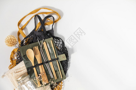 网格袋一套生态友好竹制餐具和白色背景的网状袋可持续生活方式无塑料概念背景