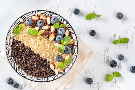 一碗白红和黑的加坚果蓝莓煮熟quinoa鸡尾酒图片