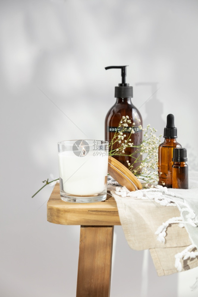 白香蜡烛体液基本油和木制长椅上的精细花朵天然有机化妆品芳香疗法信息生态产品图片