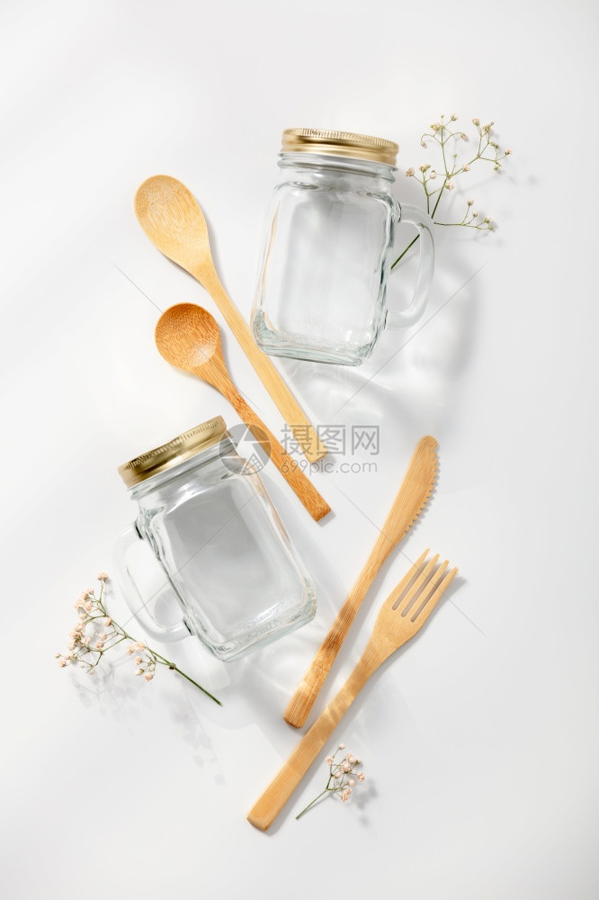 白色背景的玻璃罐和竹餐具图片