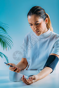 移动健康测量智能电话中的血压和输入数据字健康血压监测器与智能电话相结合背景图片