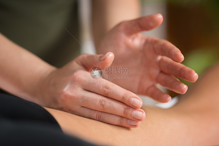 生理治疗师对腿部肌肉受伤的女病人进行按摩的近距离图像图片