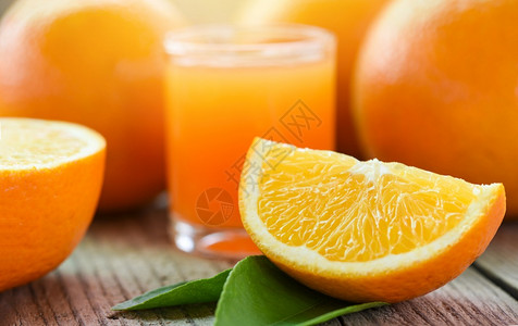 健康的水果和橙片玻璃中的新鲜橙子汁木制的水果图片