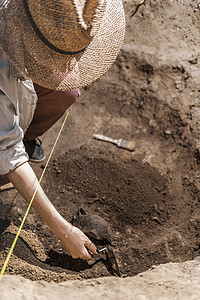 挖掘工具考古学家用手表挖掘从考古遗址中回收老陶器背景