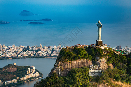 里约基督山里约热内卢市上俯瞰的Redemer市的基督雕像空中观光从直升机上发射背景