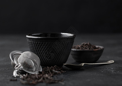 黑茶铁杯和叶银汤匙黑茶叶松散银汤匙背景图片