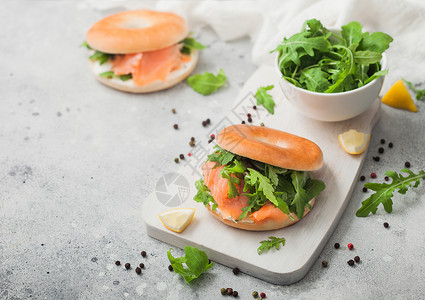 新鲜三明治配有鲑鱼和面包奶油酪和野生火箭放在轻厨房桌上的白碗中图片