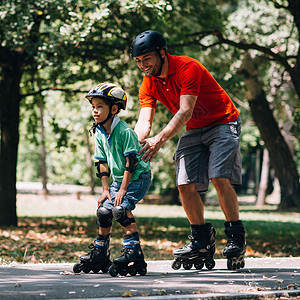 滚筒速度滑冰父亲在公园里玩滑溜背景