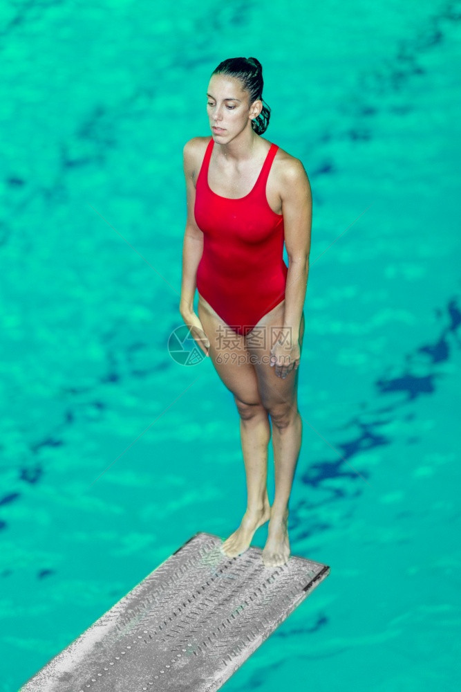 女潜水员站在跳板上准备进游泳池图片
