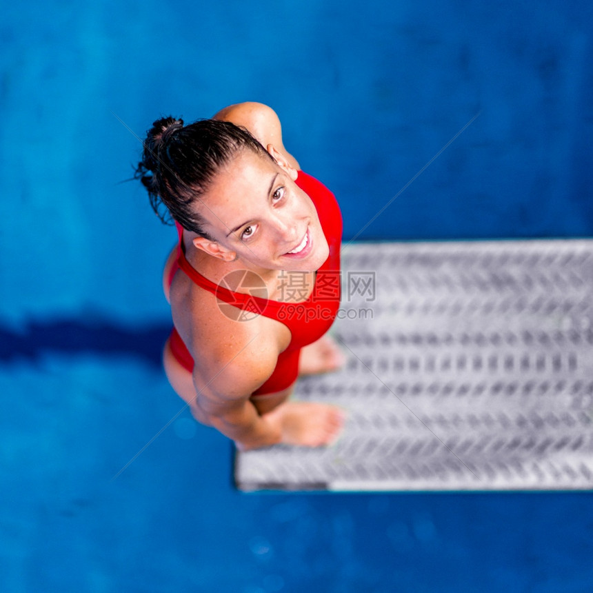女潜水员站在跳板上准备进游泳池图片