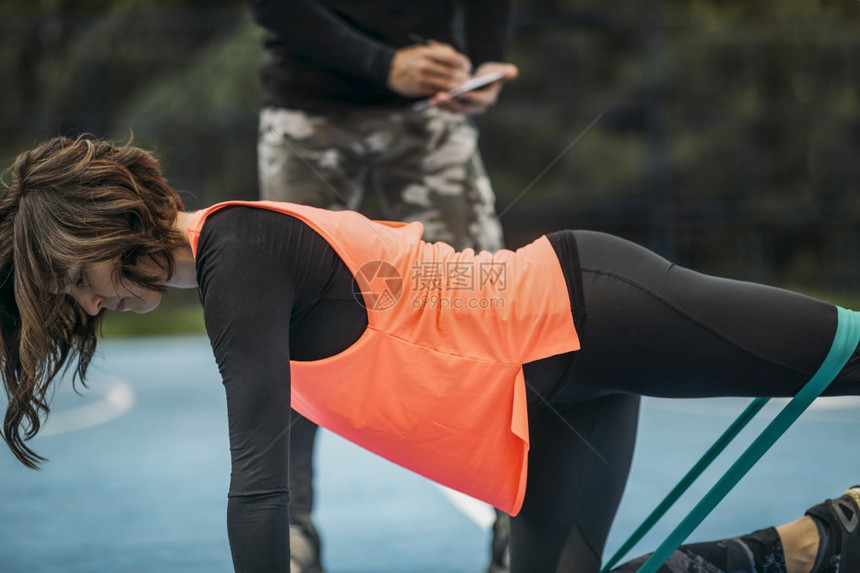 青年运动女员与个人健身教练一起在户外锻炼图片