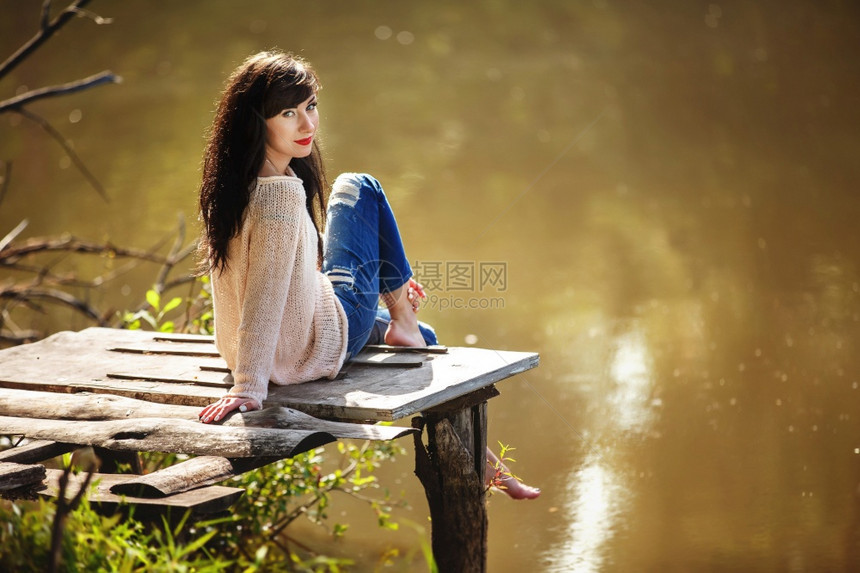 坐在老桥上赤脚的年轻女子夏天绿林湖和晚上的空气带来一种放松冥想享受自然和梦幻的心情图片