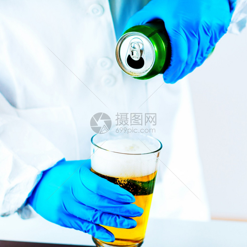 在实验室检查啤酒的质量控制专家图片