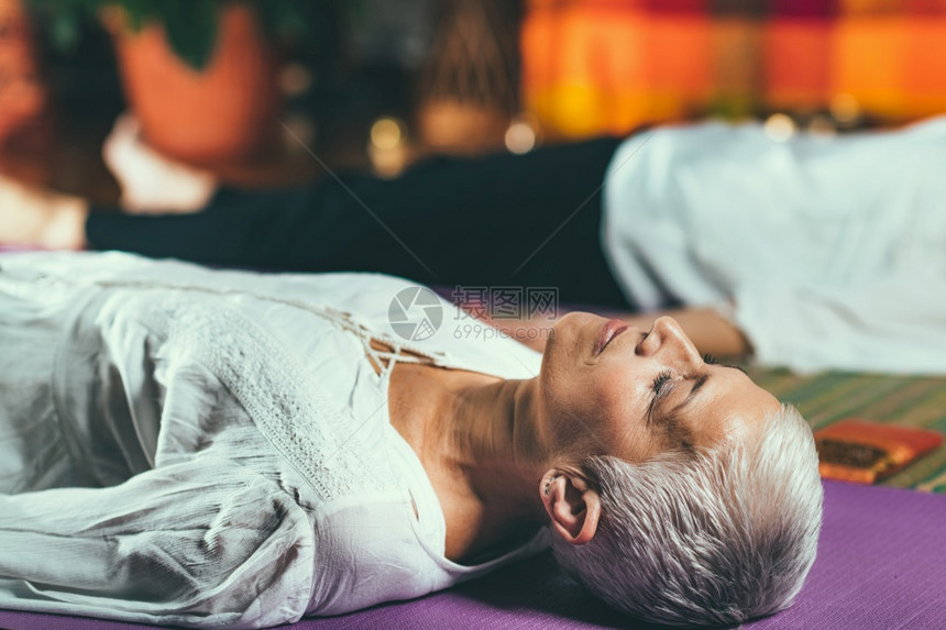 沉睡在地板上的年长妇女冥想图片