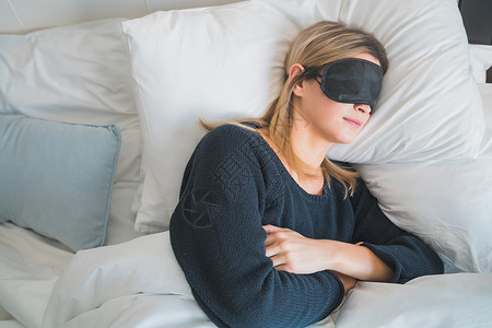 旅行者妇女在馆房间放松和安稳地睡着时戴面具图片