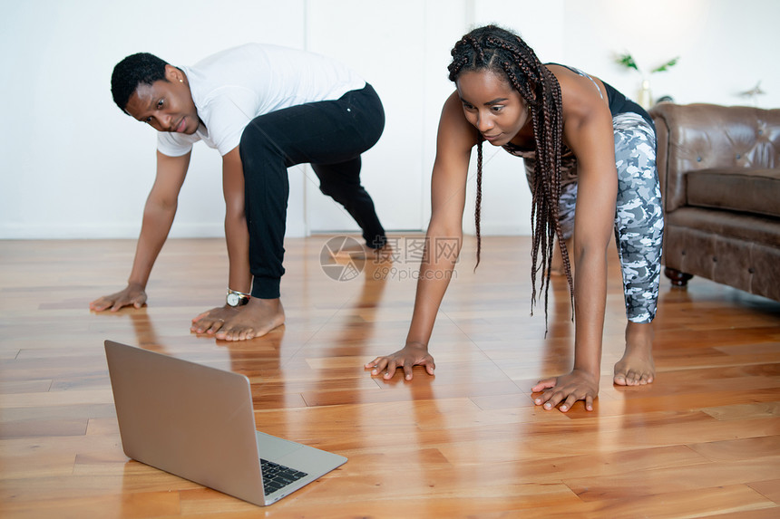 一对夫妇起锻炼的肖像他们在家时笔记本电脑上观看录像辅导体育概念新的正常生活方式概念图片