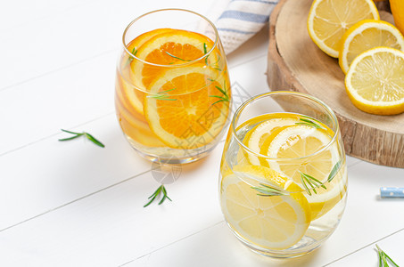 准备柠檬汁和橙水在罐子和柠檬露天桌上的迷迭香图片