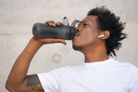 非洲运动员饮用水和在户外休息体育和健康的生活方式概念图片
