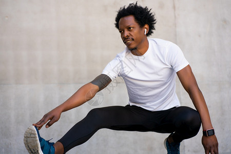 非洲运动员在户外锻炼前伸展腿部和暖身图片