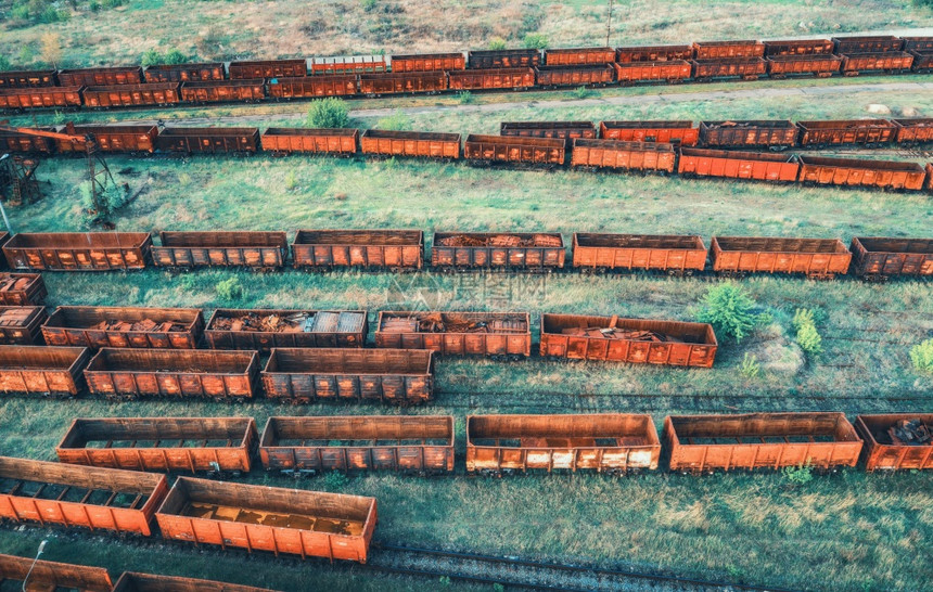 火车的空中景象铁路上老旧的生锈马车顶部景象重工业夏季日落时带火车的工业景观绿树和草丛火车站运输图片