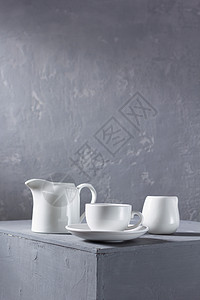空的陶瓷或盘成套设备在墙背景纹理附近灰色表面的厨房餐具和图片