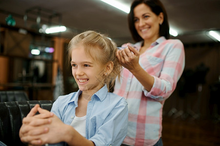妈和小女孩一起玩发型快乐的童年迷人家庭妈在沙龙对她的女儿做发型图片