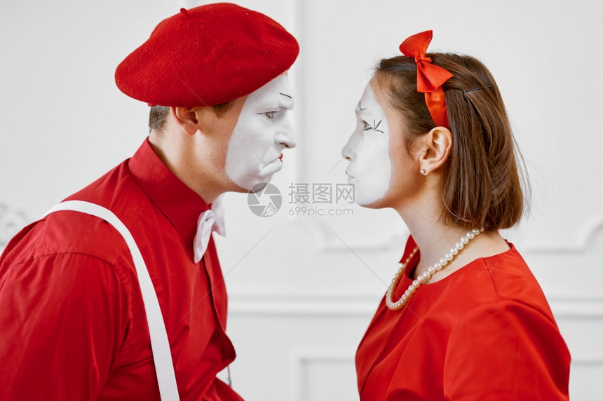 两个穿红色服装的模仿艺术家互相看对方Pantomime剧院喜演员积极的情感幽默表演有趣的面孔模仿和严酷Mime艺术家们互相看对方图片
