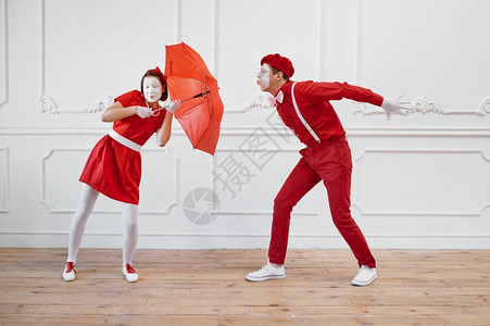 Mime艺术家风天气中带伞的场景Pantomime剧院喜演员积极的情感幽默表演有趣的面孔模仿和严酷喜剧艺术家风天气中带伞的场景图片